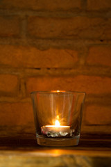 candle lit inside a glass with pine cone
