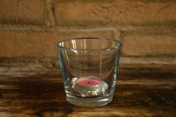 candle lit inside a glass with pine cone