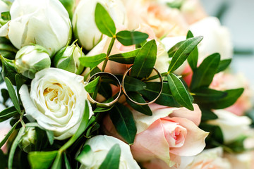 Fototapeta premium Wedding rings on a petal of a rose - studio photo