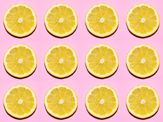 Fruit pattern. Slices of lemon on pink background