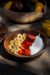 Smoothie bowls with bananas and strawberries in wooden plates