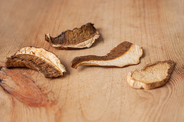 Dried edible white mushrooms on wooden background in rustic style. Superfood trend, healthy food ingredients. Dry fungi dishes vegetarian, vegan recipes.Natural wild forest fungus nutritional benefits
