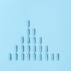  Graph of growth of incidence of coronavirus from pharmaceutical medicine pills, capsule lie on blue paper background. Medical, pharmacy and healthcare concept.