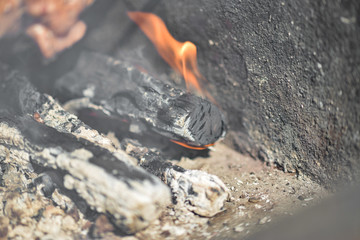 Obraz premium Burning log with coals and ash closeup.
