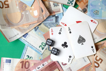 playing cards ,  game dice, money on the green poker table.  Gambling. 