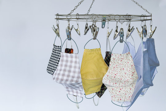 handmade clothes face masks hanging on clothes hanger after washed. Face mask is be come necessary for life this day due to Covid-19. And be come rare item. So, people made own clothes face mask.