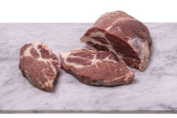 Close up view of raw pork steak isolated on marble cutting board. Food concept.