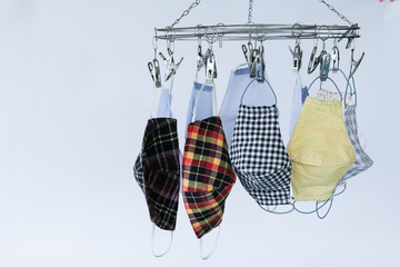 handmade clothes face masks hanging on clothes hanger after washed. Face mask is be come necessary for life this day due to Covid-19. And be come rare item. So, people made own clothes face mask.