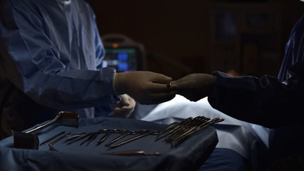 surgical instrument lying on table while group of surgeon work in operation room at hospital, emergency case, surgery, medical technology, health care cancer and disease treatment