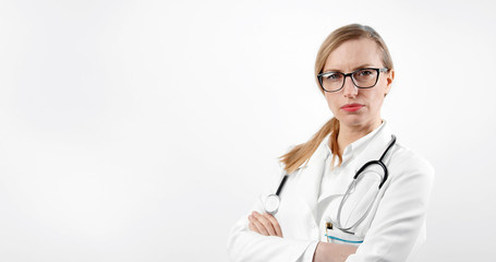 Portrait of serious medical woman with crossed arms standing over white background looking camera