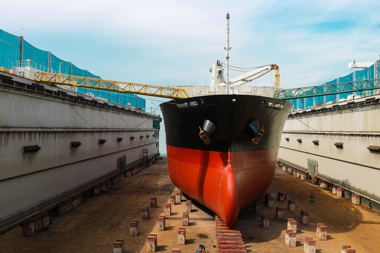 Shipyard ship repair The bulk carrier general cargo ship in dry dock yard, recondition of hull repairing and repainting, working in dry dock yard.