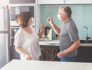 Elderly couple in medical masks during the pandemic coronavirus dancing