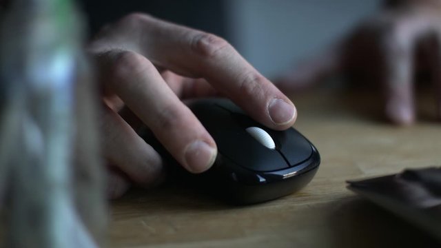Click! A finger clicks a mouse button while working on a computer. Closeup shot of mouse. Shot in 4k