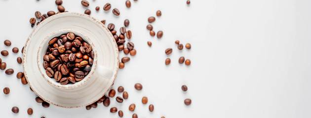 Cup of coffee and coffee beans on a white background with copy space for your text.