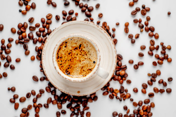 Cup of coffee and coffee beans on a white background with copy space for your text.