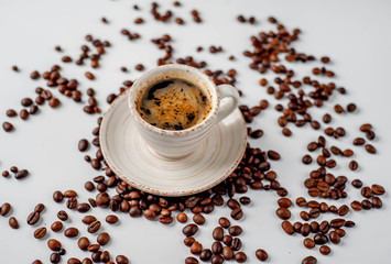Cup of coffee and coffee beans on a white background with copy space for your text.