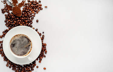 Cup of coffee and coffee beans on a white background with copy space for your text.