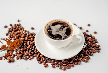 Cup of coffee and coffee beans on a white background with copy space for your text.