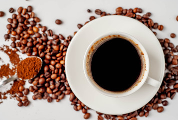 Cup of coffee and coffee beans on a white background with copy space for your text.