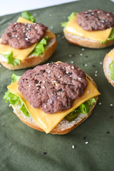 burger rolls with sesame seeds with lettuce, cheese and meat cutlet