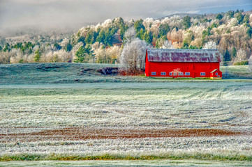 Red barn on a frosty autumn morning in the New England town of Stowe Vermont USA