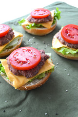 burger rolls with sesame seeds with lettuce, cheese, meat cutlet and tomato