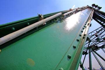 A beautiful old green bridge with steel structures.