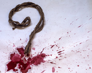 A question mark made of rope and blood spatter.