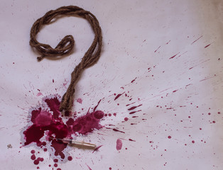 A question mark made of rope and blood spatter.