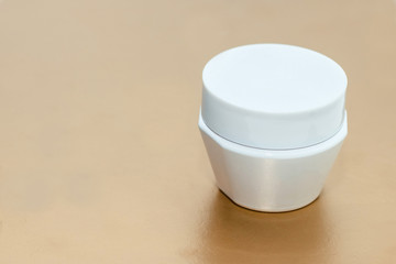face cream with an open lid. branding mock up. beauty cosmetics jar on a gold background