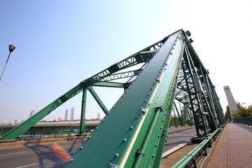A beautiful old green bridge with steel structures.