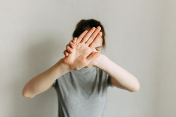 Stop domestic violence. The girl covers her face with her hand and asks for help. Domestic violence against women.