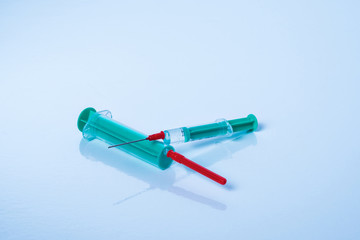 Two green syringes with vaccine on white surface Concept of prevention.