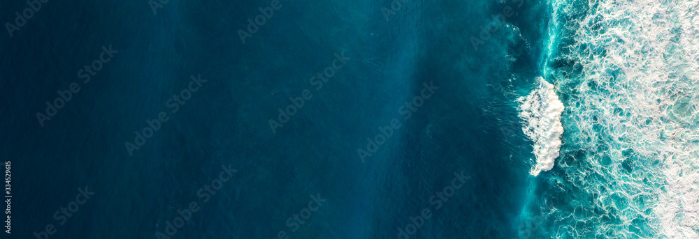 Wall mural aerial view to waves in ocean splashing waves.