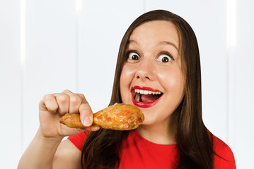 Young beautiful woman eat fast food a chicken leg