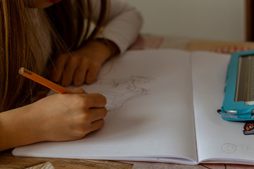 manos de niña mientras esta dibujando