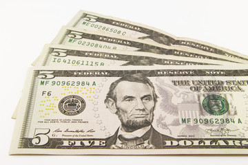 Stack of american money, five dollar cash banknotes on white background