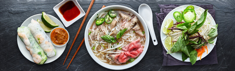 Naklejki  vietnamese beef pho with spring rolls in flat lay composition