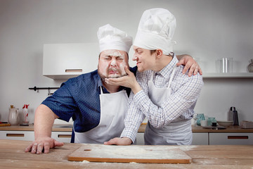 two chefs fool around in the kitchen and throw flour at each other
