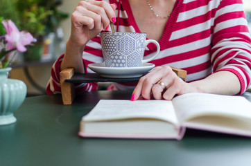 Woman reading a book with a cup of coffee