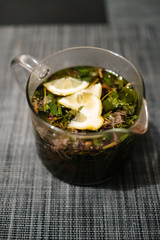 herbal tea with lemon in a teapot in a glass