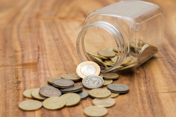 coins spilling out of glass jar