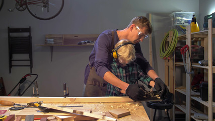 Master teaches little boy to polish wood board