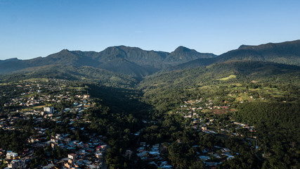 Aerial view of city in peruvian amazon jungle - forest and mountains in the background. Green area, vegetation