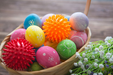 Virus model of Coronavirus disease COVID-19 with colorful easter eggs in basket with flowers on a wooden table background
