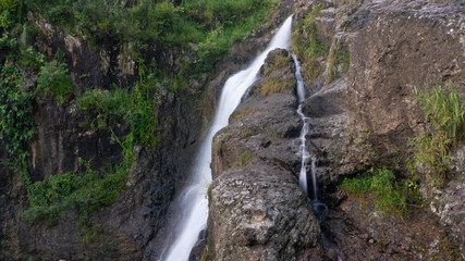 Fototapeta na wymiar Cliffs with soft waterfalls in the hills