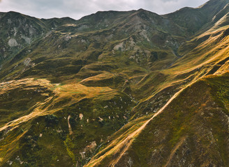 Majestic mountain shapes of Caucasus high altitude meadows and valleys during the sunset