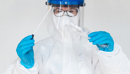 Female doctor or nurse in protective suit takes a specimen swab