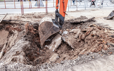 Construction works on rusty iron pipes at a depth of excavated trench
