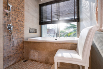 Bathtub near window and white chair of pool villa, house, home, condo and apartment